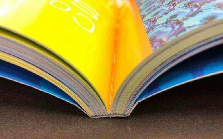 Libro con encuadernación rústica cosida por cuadernillos abierto de plano, impreso en Rocco Gráficas Medellín
