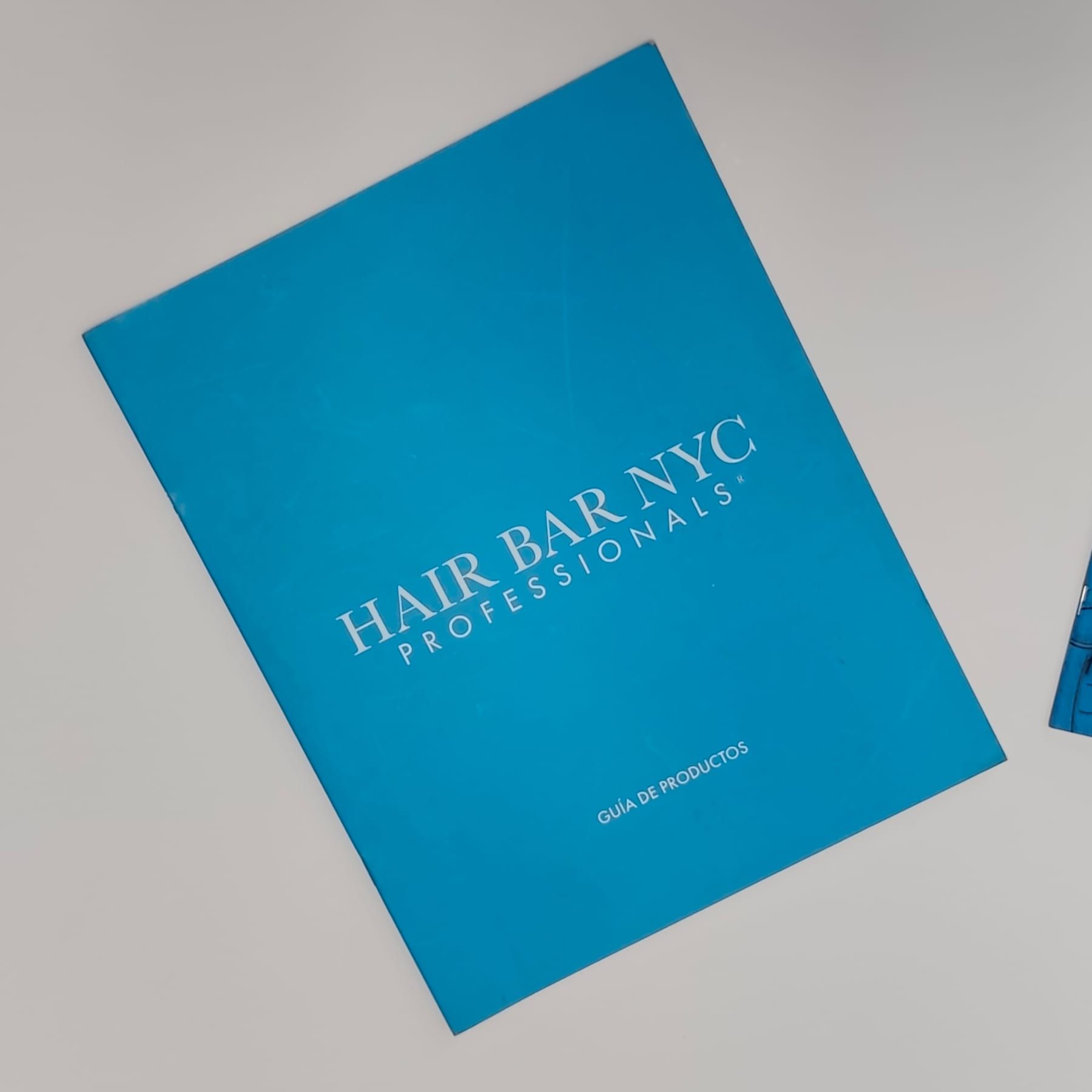 Carpeta azul de Hair Bar NYC Professionals para guía de productos, impresa a todo color