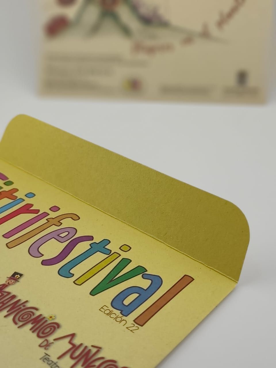 Detalle de la solapa abierta de un sobre kraft con impresión a color y troquel redondeado