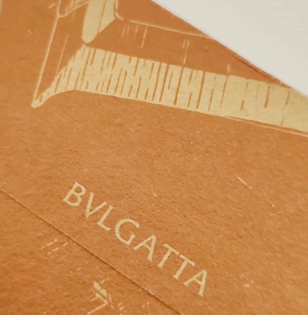 Orange BVLGATTA envelope printed at Rocco Gráficas, with the brand in cream ink
