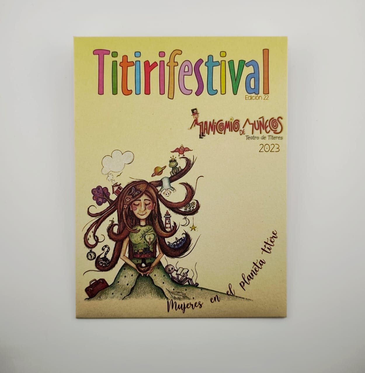 Sobre kraft impreso a todo color con el arte del Titirifestival 2023, visto de frente sobre fondo neutro